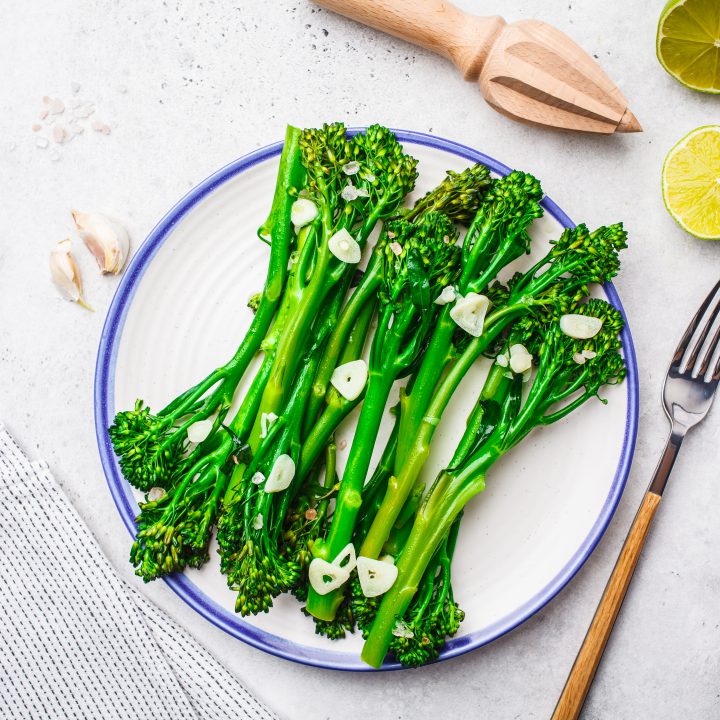 Boiled broccolini with garlic white plate